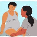 Doula comforting mother during early childbirth labor.