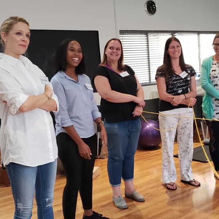 group of ladies standing in front of the room